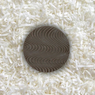 One piece of sugar-free Goalz chocolate with wavy designs lying on a bed of coconut shreds