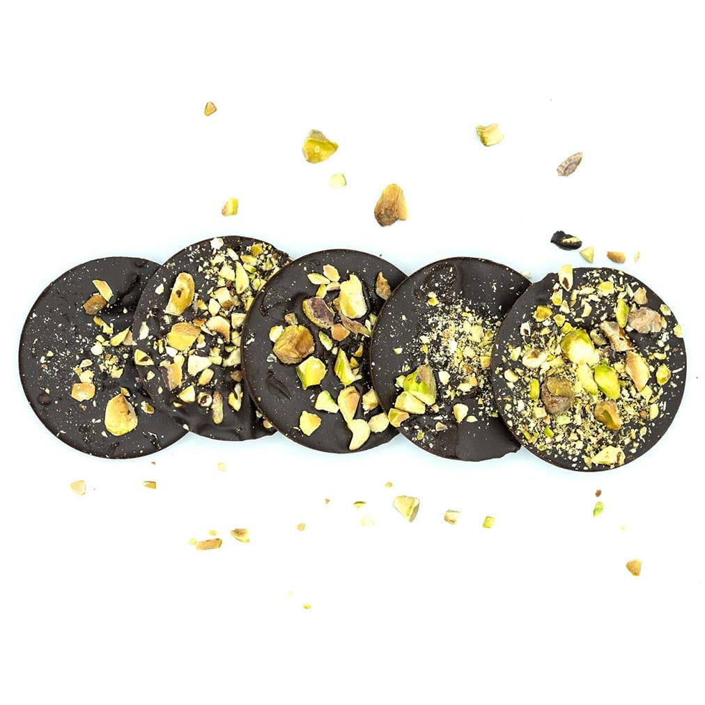 Disc shaped Keto Chocolate bars with pistachio pieces on it. 