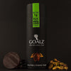 Allulose Sweetened Goalz Dark Chocolate with Pistachios and with 1g net carb per serving. The black chocolate canister standing next to shelled organic pistachios and sugar-free chocolate bars. The canister has a goalz logo and text that says Chocolate minus carb. There is a orange copper metallic cocoa pods with cocoa beans showing under the logo. At the bottom it says Keto, Paleo, Diabetic, and Vegan  
