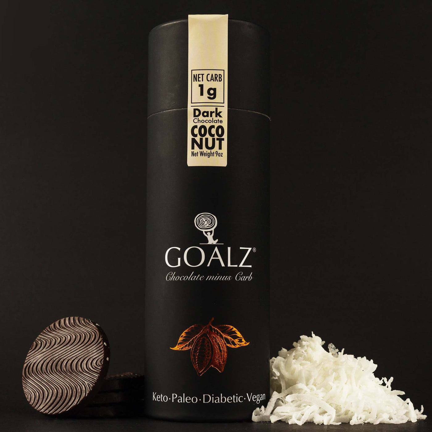 Allulose based dark chocolate with organic coconut flakes. White Goalz logo on a black box and text under logo that says Chocolate minus Carb. Chocolate discs are on the left and coconut shreds on the right